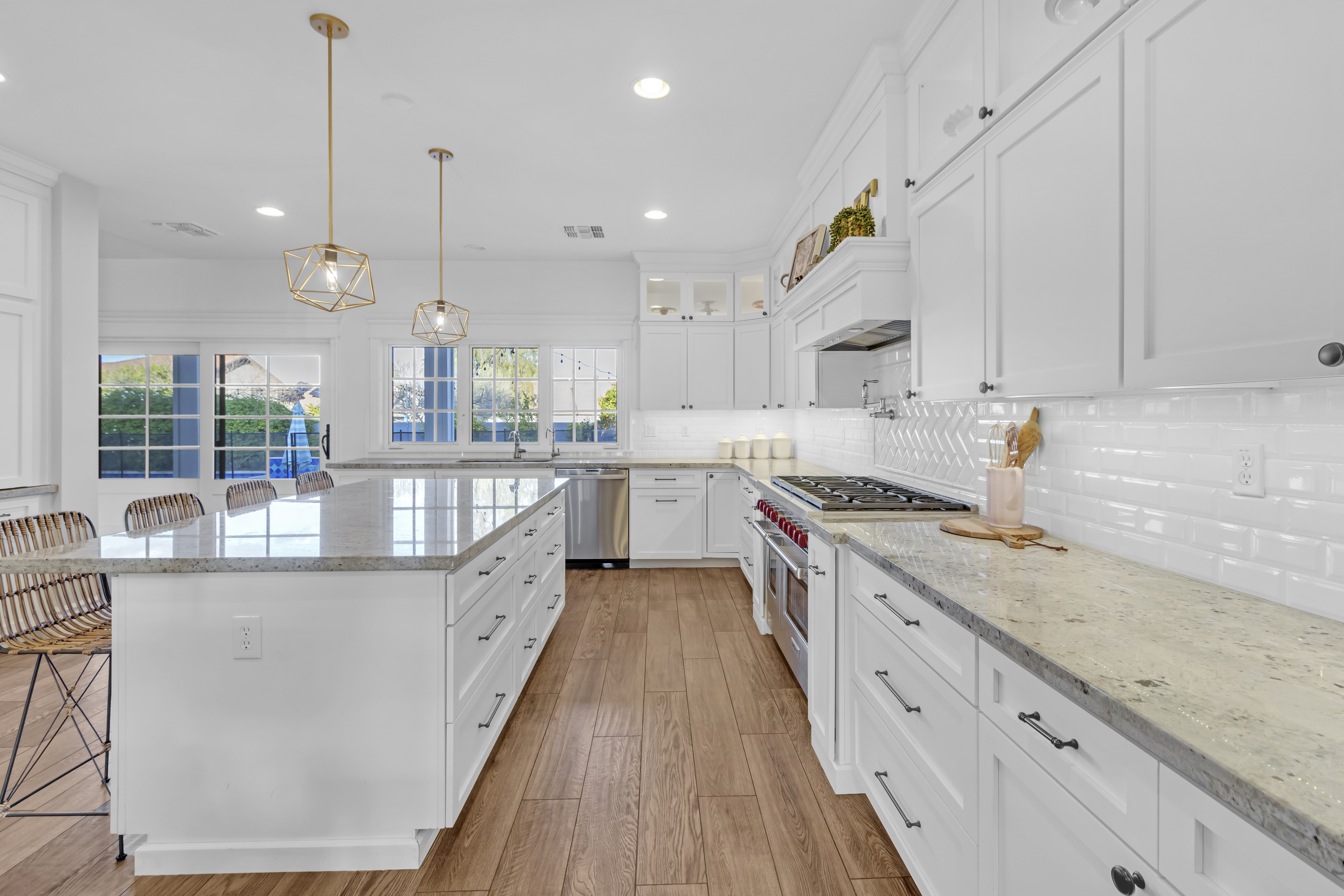 White kitchen with gold pendant lights and granite countertops